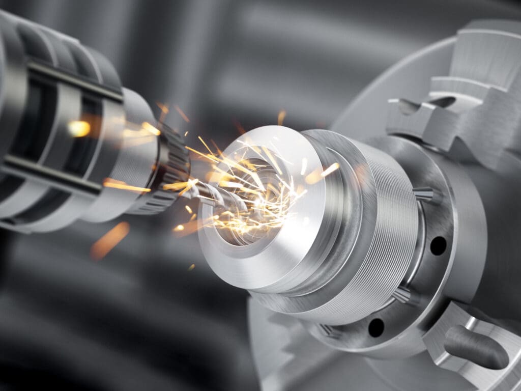 A close-up of a CNC machine cutting a metal part, with bright sparks flying from the point of contact between the cutting tool and the rotating metal workpiece.