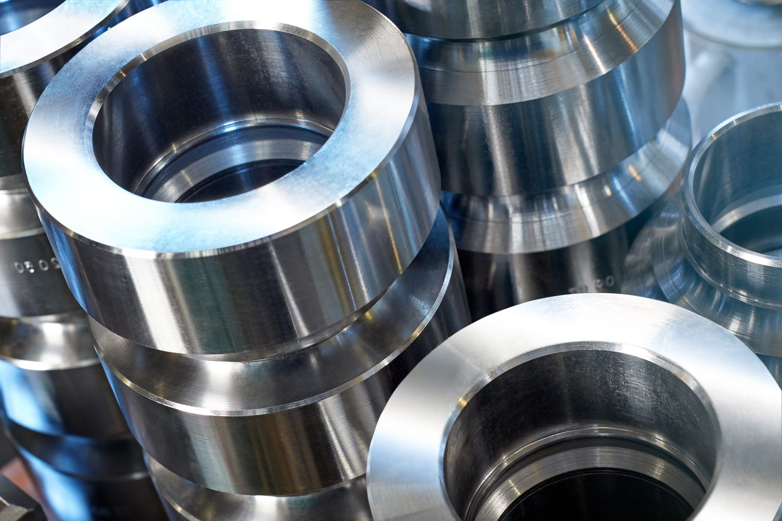A close-up view of stacked shiny metal rings or cylindrical components with smooth, reflective surfaces, likely used in industrial or mechanical applications.